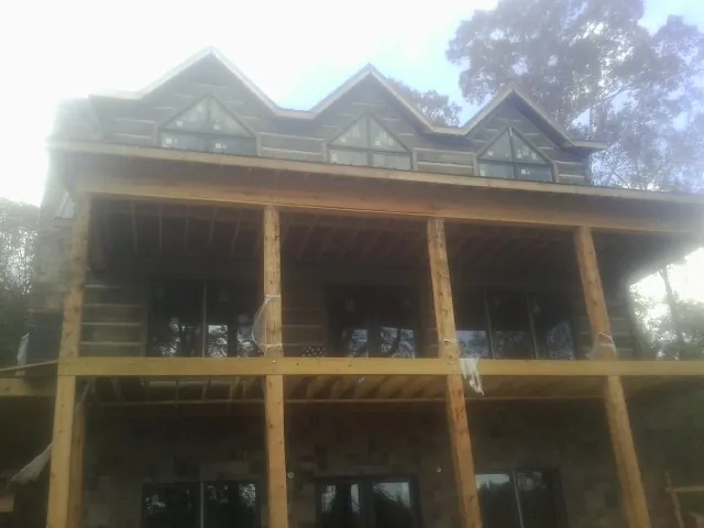 Dormers and porch framing on a large log home under construction — Roof Coating work by our crew in Snoqualmie Pass